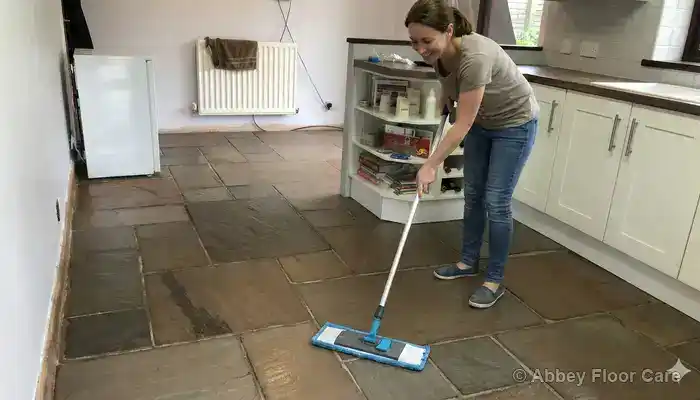 Gentle routine cleaning of a porous sandstone floor using a soft mop